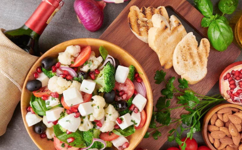 Greek salad or horiatiki with large pieces of tomatoes, cucumbers, onion, feta cheese and olives in white bowl isolated top view. village salad with diced mozzarella, arugula, parsley and olive oil